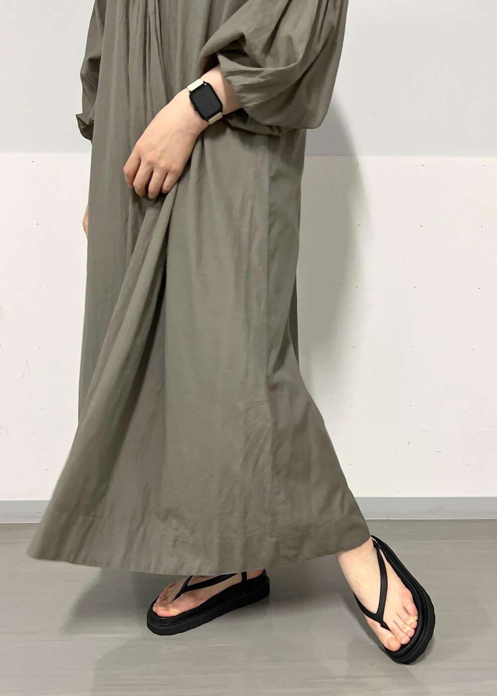 ブラック系のサンダル、グレー系のワンピース、ブラック系のかごバッグを着用したレディースの春コーディネートの7枚目の写真