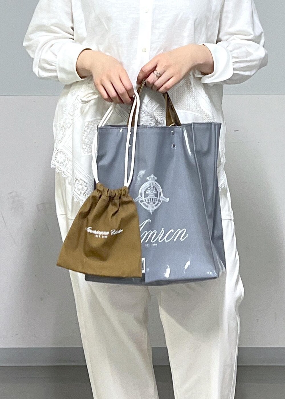 ブルー系のトートバッグ、ホワイト系のシャツ/ブラウス、ベージュ系のニット/セーターを着用したレディースの冬コーディネートの8枚目の写真