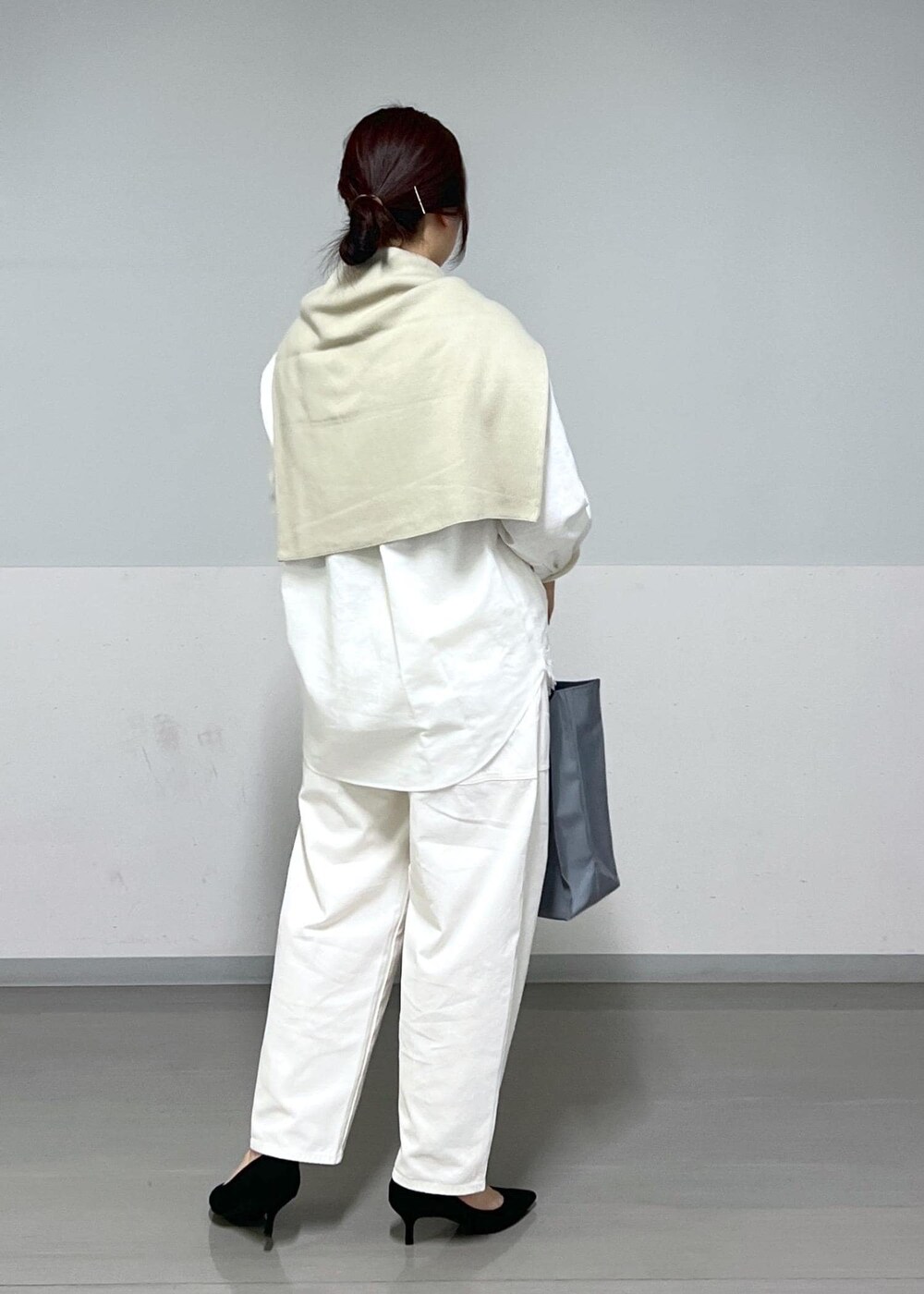 ブルー系のトートバッグ、ホワイト系のシャツ/ブラウス、ベージュ系のニット/セーターを着用したレディースの冬コーディネートの4枚目の写真