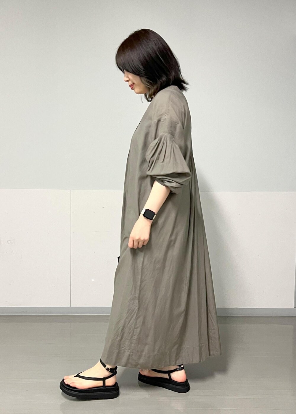 ブラック系のサンダル、グレー系のワンピース、ブラック系のかごバッグを着用したレディースの春コーディネートの3枚目の写真