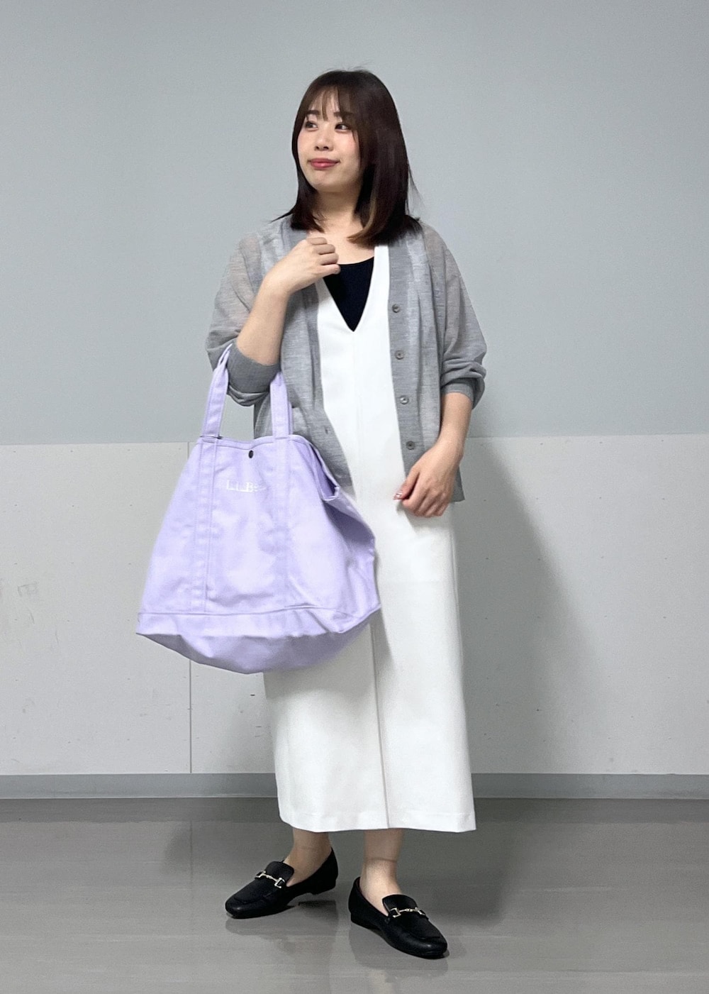 シルバー系のカーディガン/ボレロ、ホワイト系のジャンパースカート、パープル系のトートバッグを着用したレディースの夏コーディネートの2枚目の写真