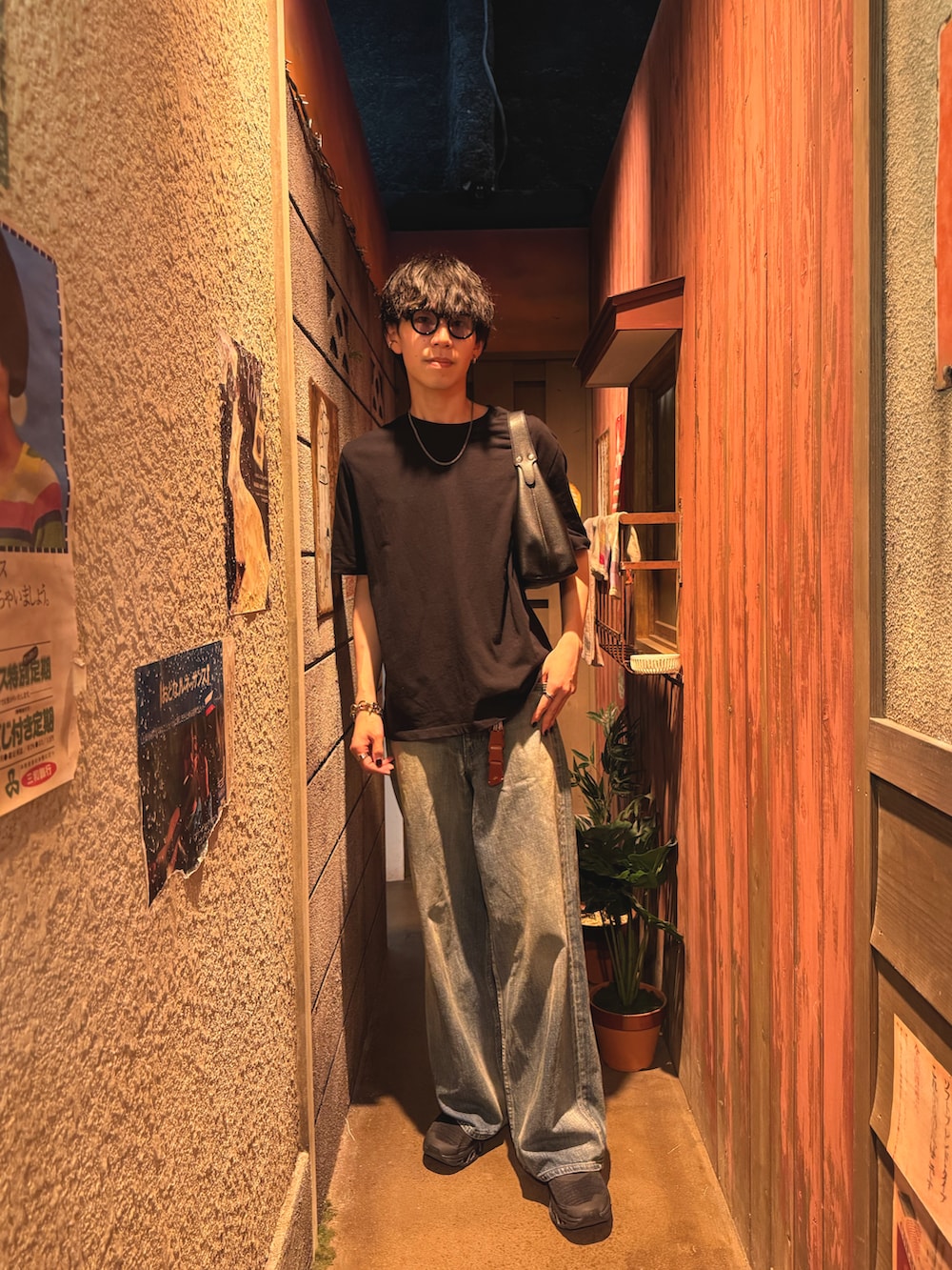 ブラック系のTシャツ/カットソー、ブルー系のデニムパンツ、ブラック系のスニーカーを着用したメンズの夏コーディネートの3枚目の写真