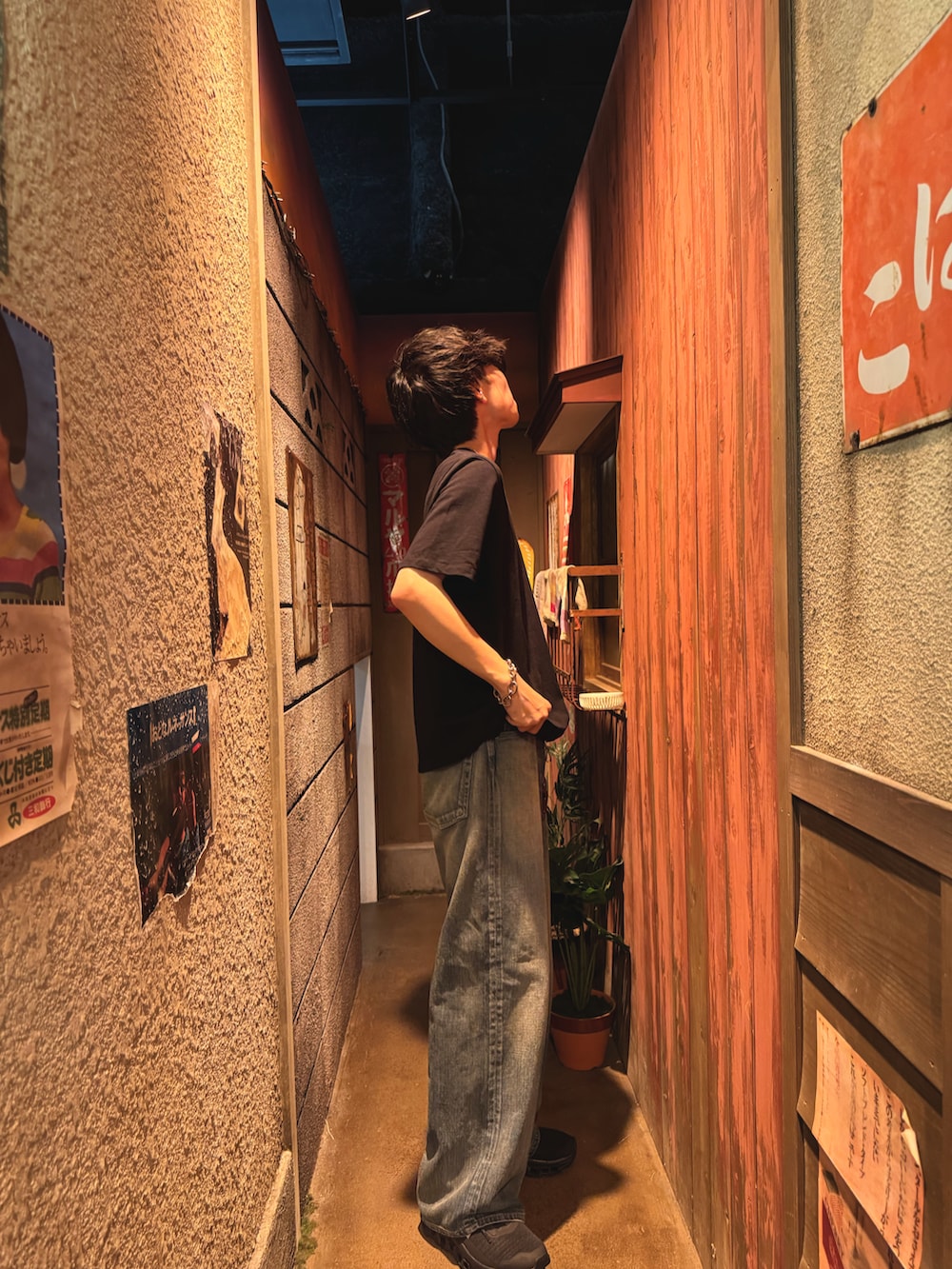 ブラック系のTシャツ/カットソー、ブルー系のデニムパンツ、ブラック系のスニーカーを着用したメンズの夏コーディネートの2枚目の写真