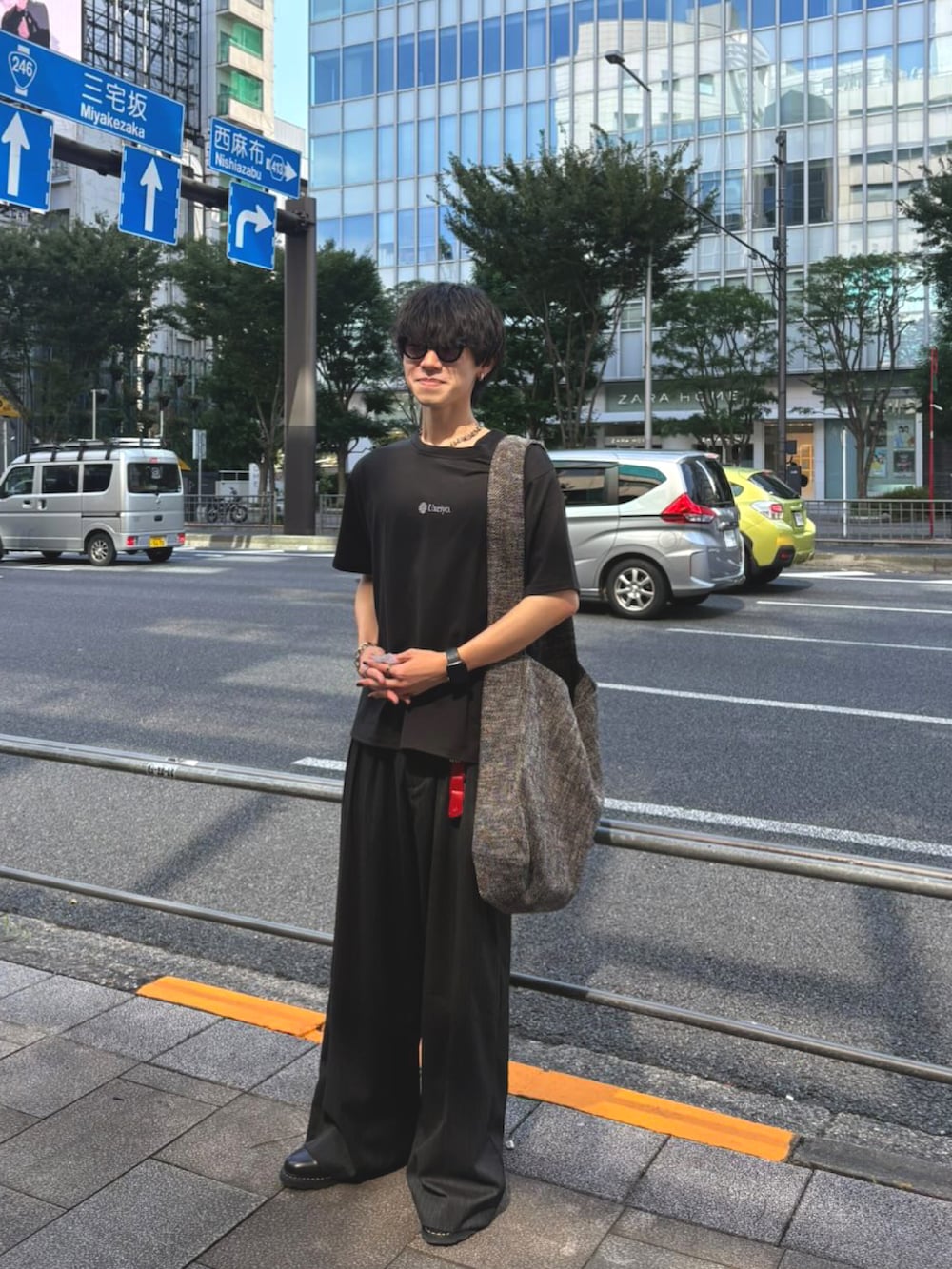 グレー系のスラックス、ブラック系のドレスシューズ、グレー系のショルダーバッグを着用したメンズの秋コーディネートの3枚目の写真