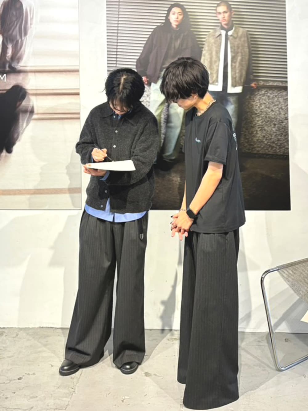 グレー系のスラックス、ブラック系のドレスシューズ、グレー系のショルダーバッグを着用したメンズの秋コーディネートの4枚目の写真
