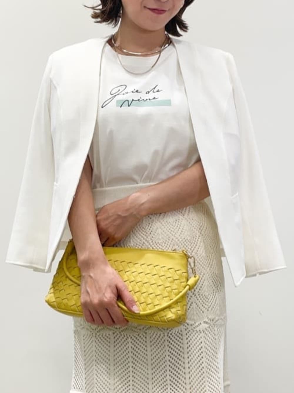 ホワイト系のスカート、ホワイト系のノーカラージャケット、ホワイト系のTシャツ/カットソーを着用したレディースの夏コーディネートの4枚目の写真