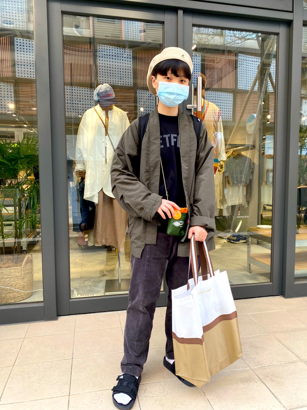 グリーン系のノーカラージャケット、ブラック系のその他トップス、ブラック系のその他シューズを着用したレディースの春コーディネートの3枚目の写真