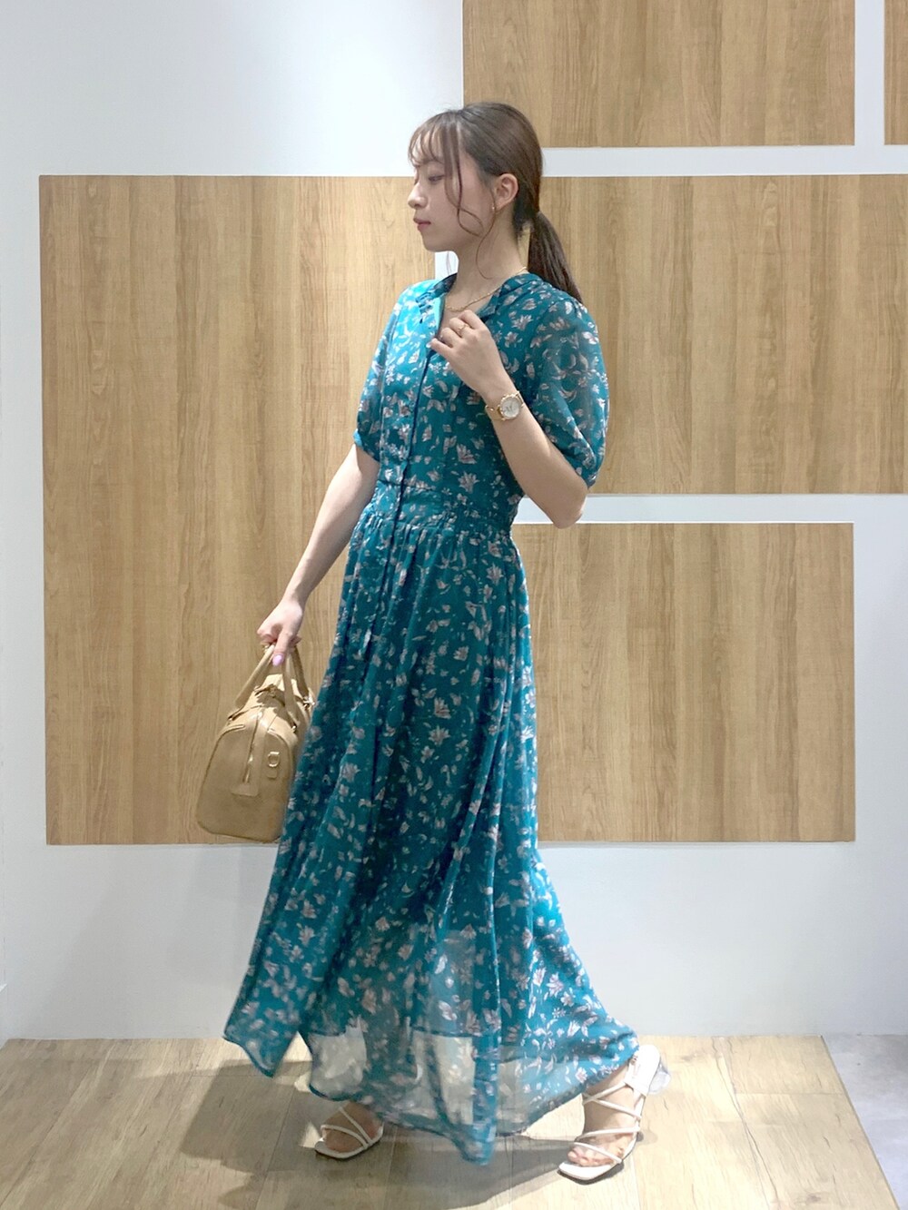 グリーン系のワンピース、ホワイト系のサンダル、ベージュ系のボストンバッグを着用したレディースの春コーディネートの2枚目の写真