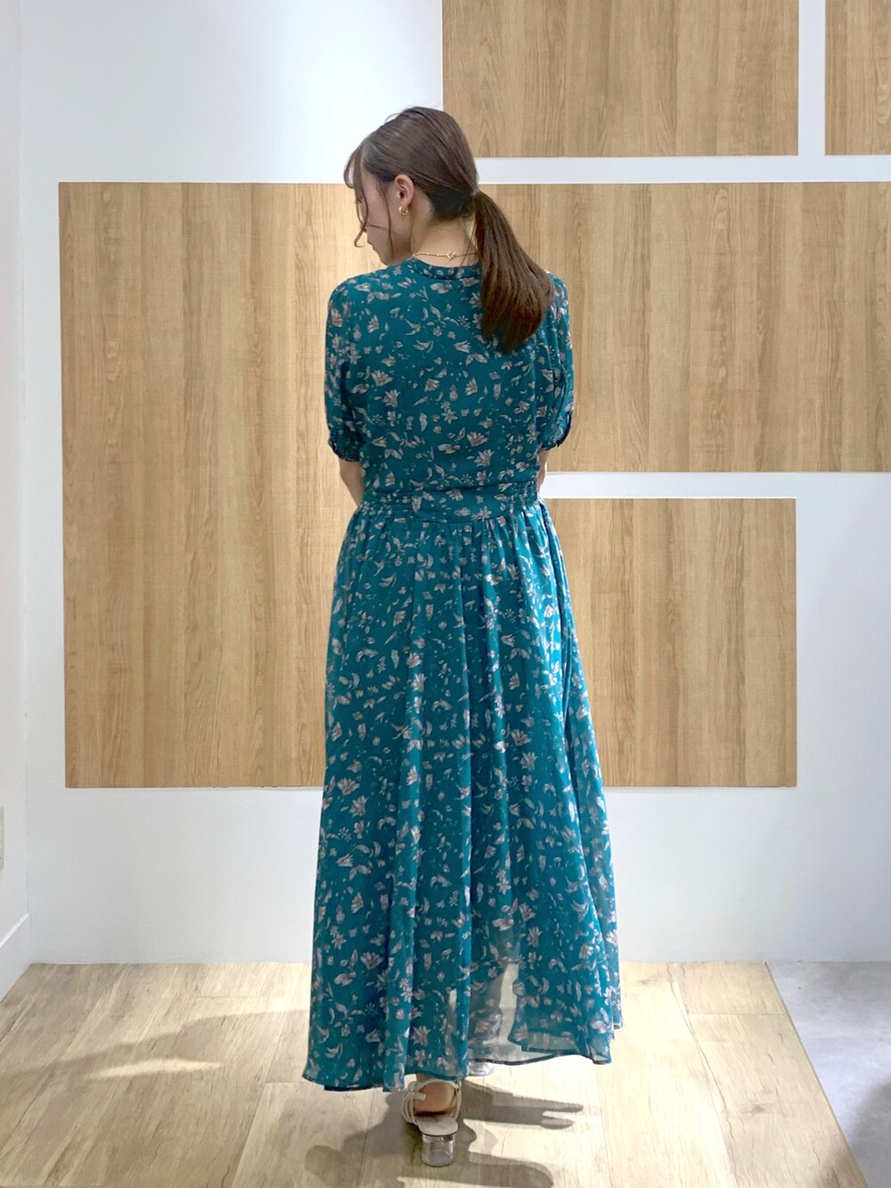 グリーン系のワンピース、ホワイト系のサンダル、ベージュ系のボストンバッグを着用したレディースの春コーディネートの3枚目の写真