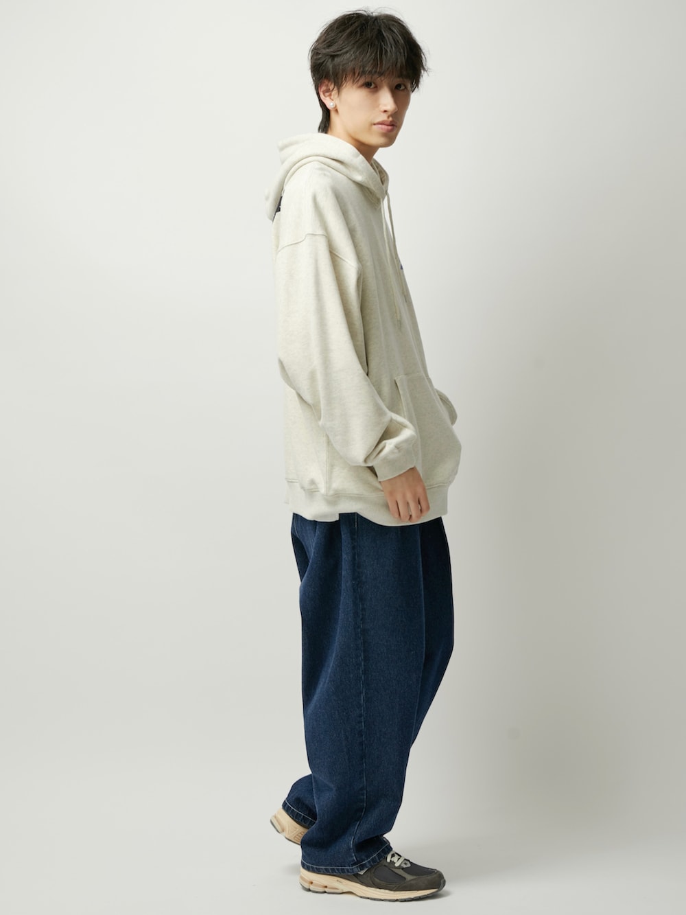 ブルー系のデニムパンツ、グレー系のパーカーを着用したメンズの秋コーディネートの2枚目の写真