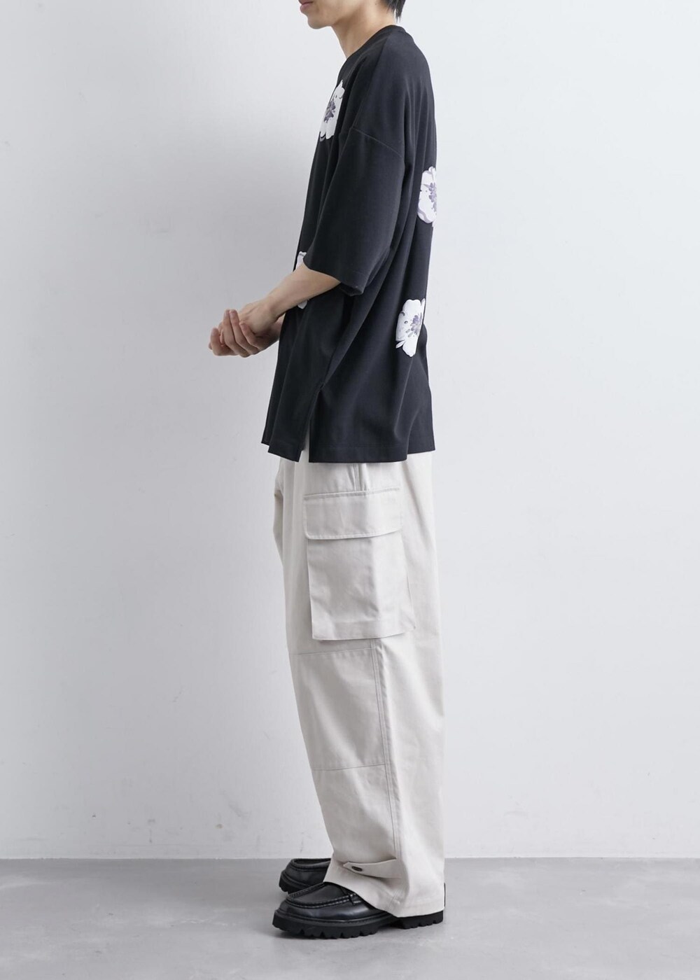 ベージュ系のカーゴパンツ、ブラック系のTシャツ/カットソーを着用したメンズの夏コーディネートの2枚目の写真