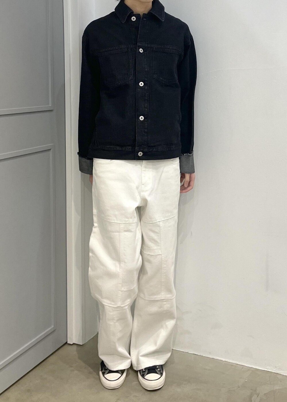 ブラック系のブルゾン、ホワイト系のデニムパンツを着用したメンズの冬コーディネートの4枚目の写真