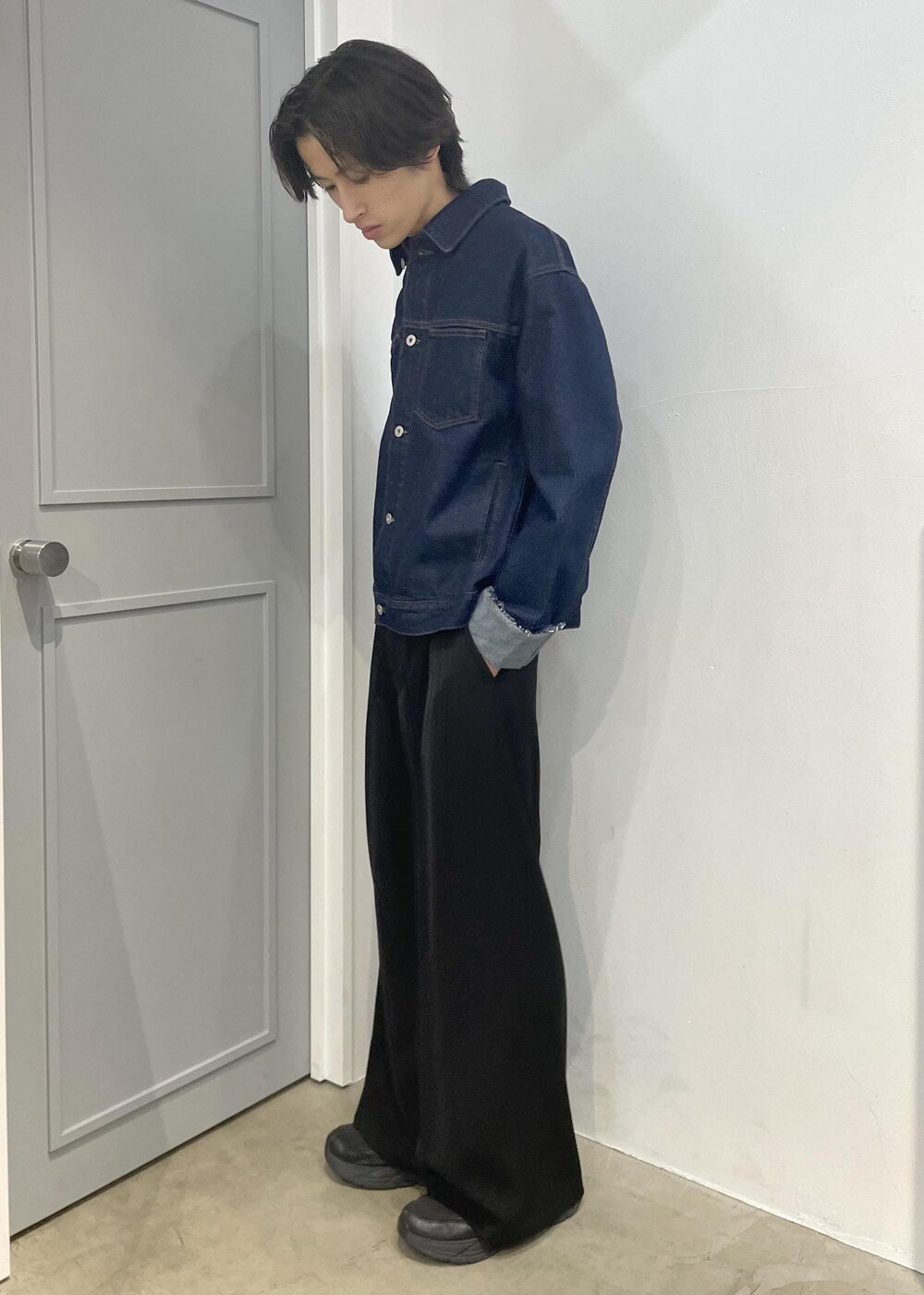 ブルー系のブルゾン、ブラック系のスラックスを着用したメンズの冬コーディネートの2枚目の写真