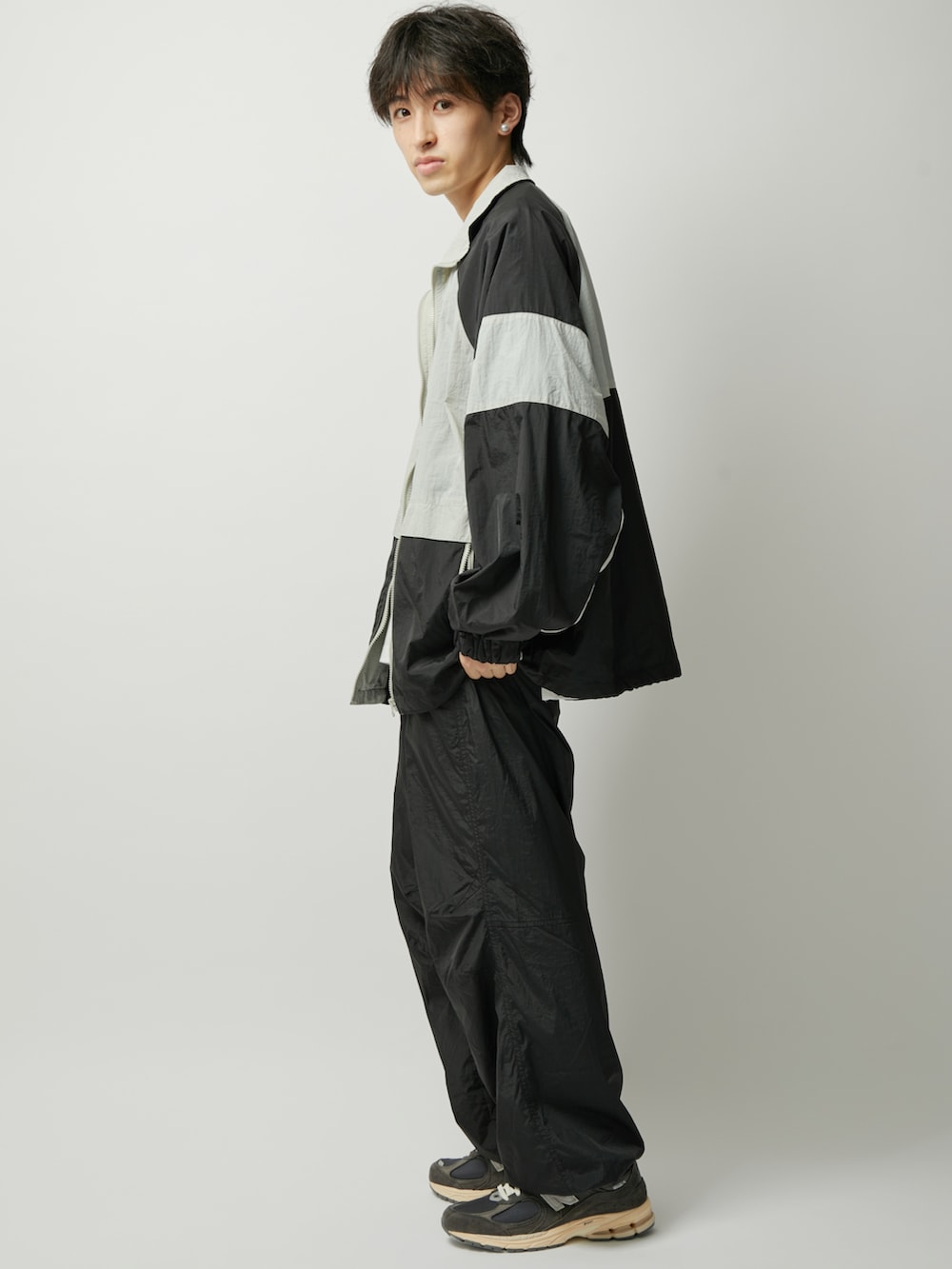 ブラック系のその他パンツ、ブラック系のナイロンジャケットを着用したメンズの夏コーディネートの2枚目の写真