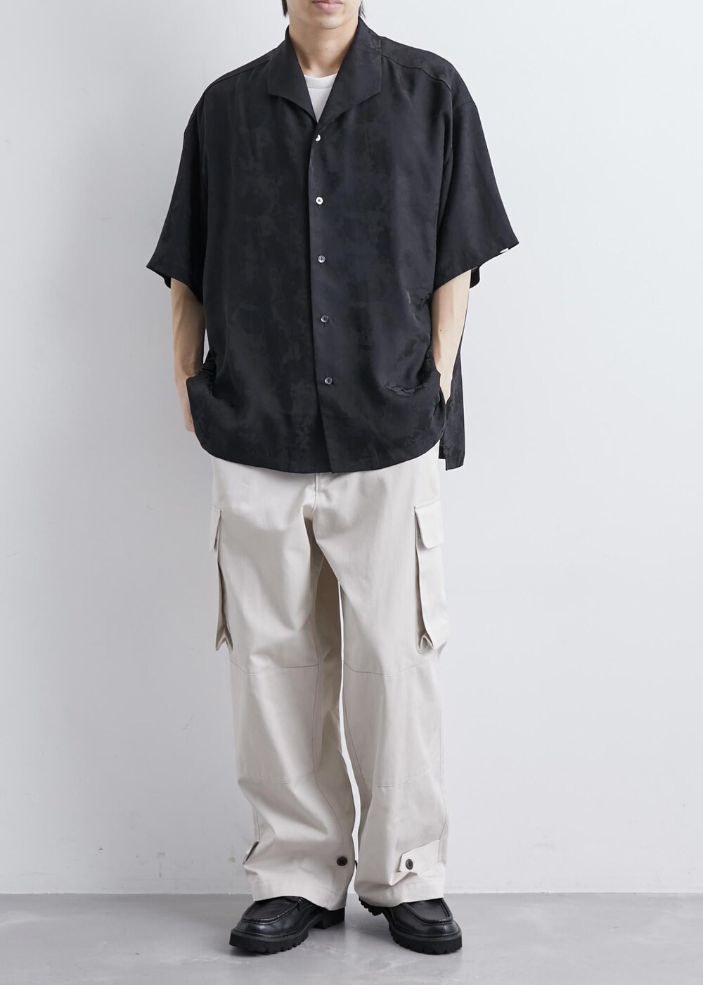 ベージュ系のカーゴパンツ、ブラック系のシャツ/ブラウスを着用したメンズの夏コーディネートの2枚目の写真