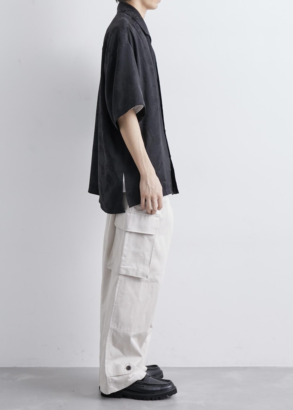 ベージュ系のカーゴパンツ、ブラック系のシャツ/ブラウスを着用したメンズの夏コーディネートの2枚目の写真