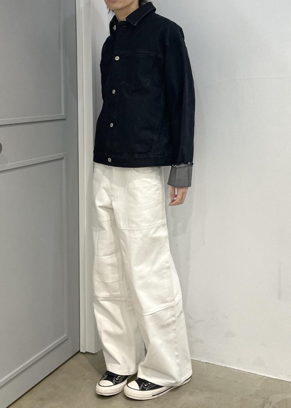 ブラック系のブルゾン、ホワイト系のデニムパンツを着用したメンズの冬コーディネートの2枚目の写真