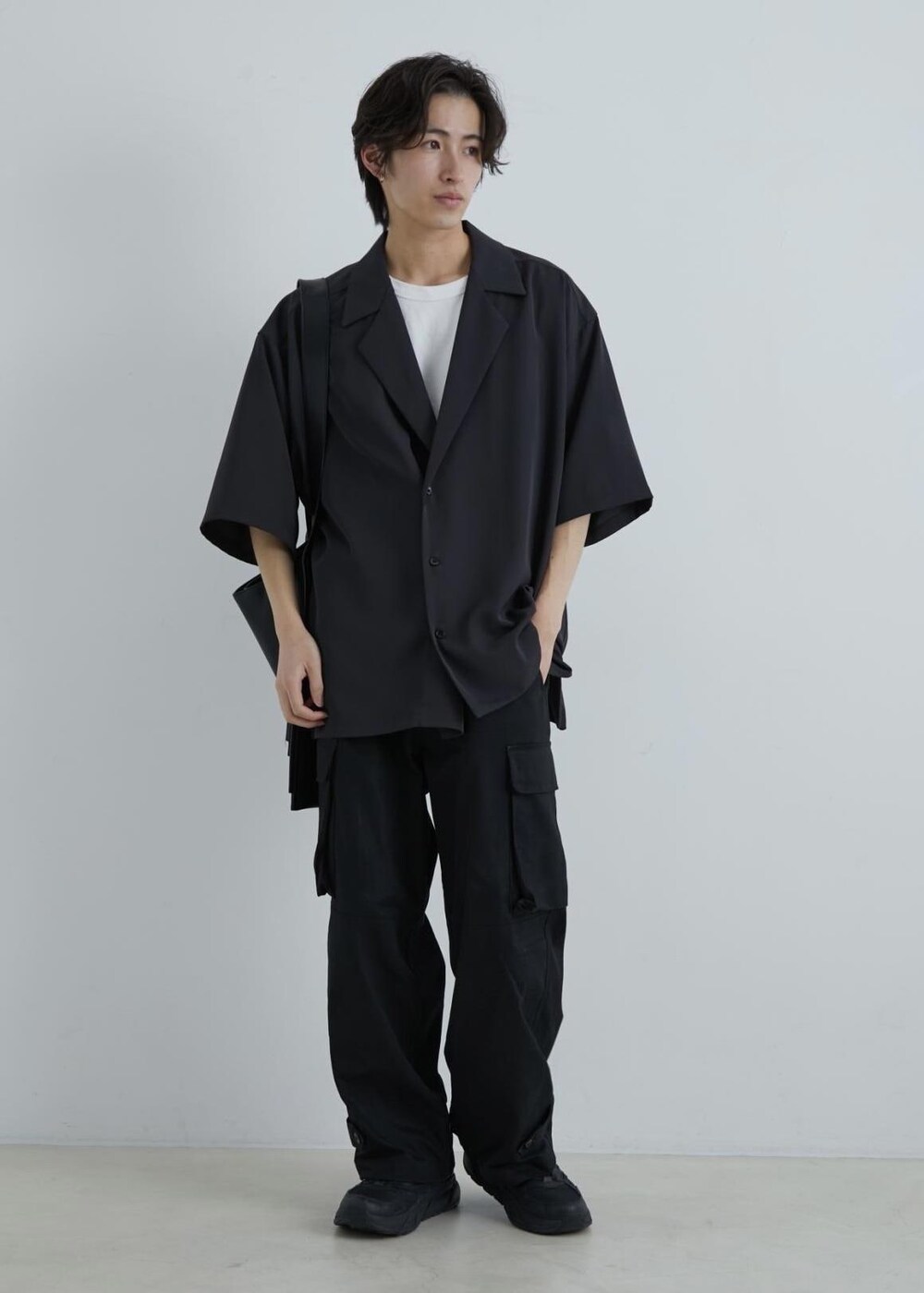 ブラック系のカーゴパンツ、ブラック系のシャツ/ブラウス、ブラック系のショルダーバッグを着用したメンズの春コーディネートの2枚目の写真