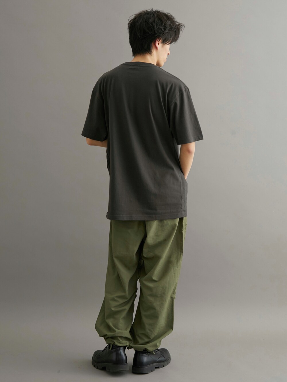 グリーン系のカーゴパンツ、ブラック系のTシャツ/カットソーを着用したメンズの夏コーディネートの3枚目の写真