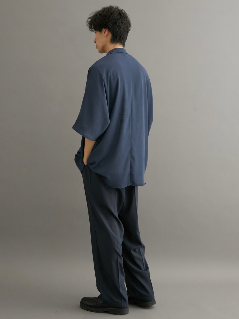 ブラック系のスラックス、ブルー系のシャツ/ブラウス、ホワイト系のTシャツ/カットソーを着用したメンズの夏コーディネートの2枚目の写真