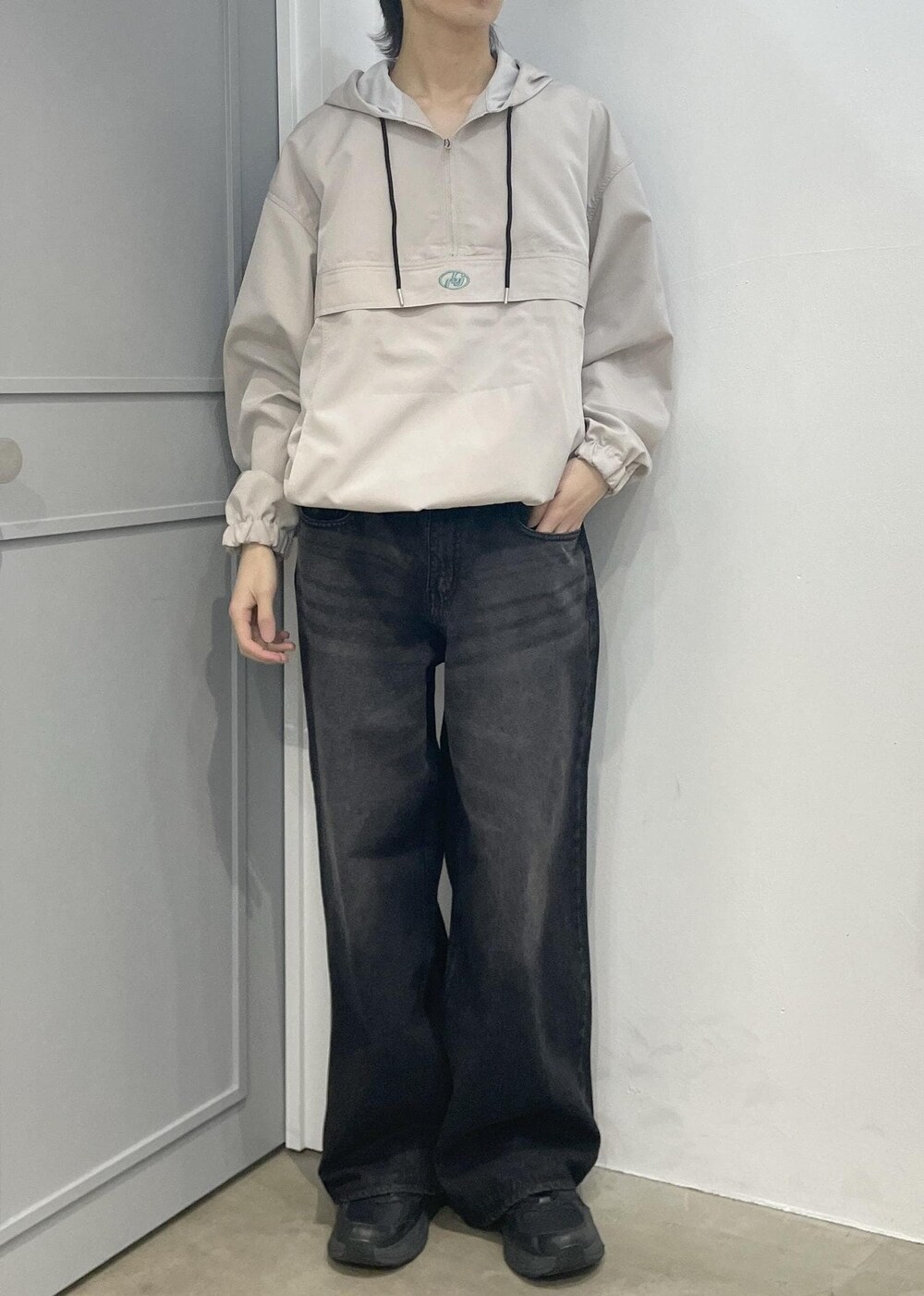 ブラック系のデニムパンツ、ベージュ系のブルゾンを着用したメンズの春コーディネートの4枚目の写真