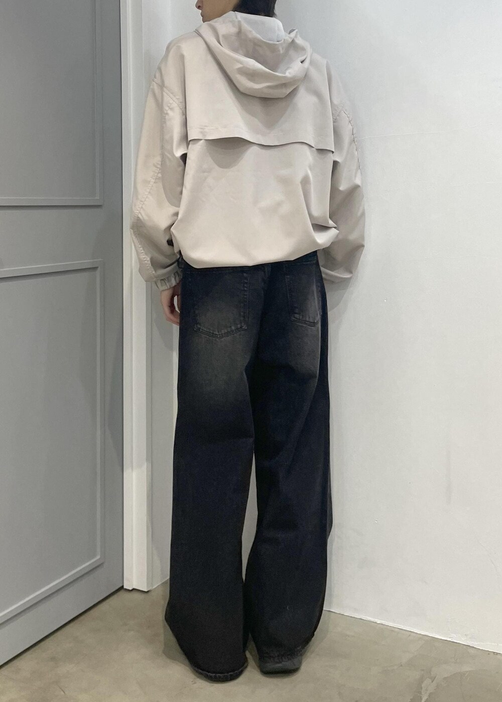 ブラック系のデニムパンツ、ベージュ系のブルゾンを着用したメンズの春コーディネートの3枚目の写真