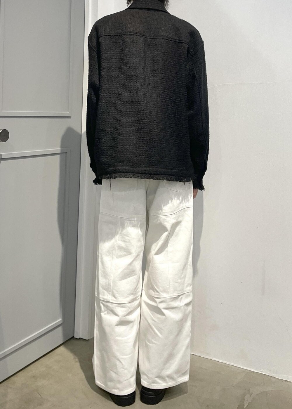 ブラック系のローファー、ホワイト系のカーゴパンツ、ブラック系のブルゾンを着用したメンズの春コーディネートの4枚目の写真