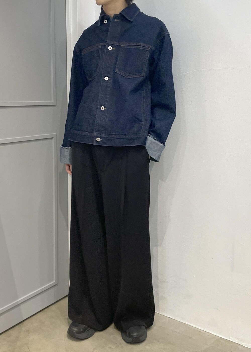 ブルー系のブルゾン、ブラック系のスラックスを着用したメンズの冬コーディネートの4枚目の写真