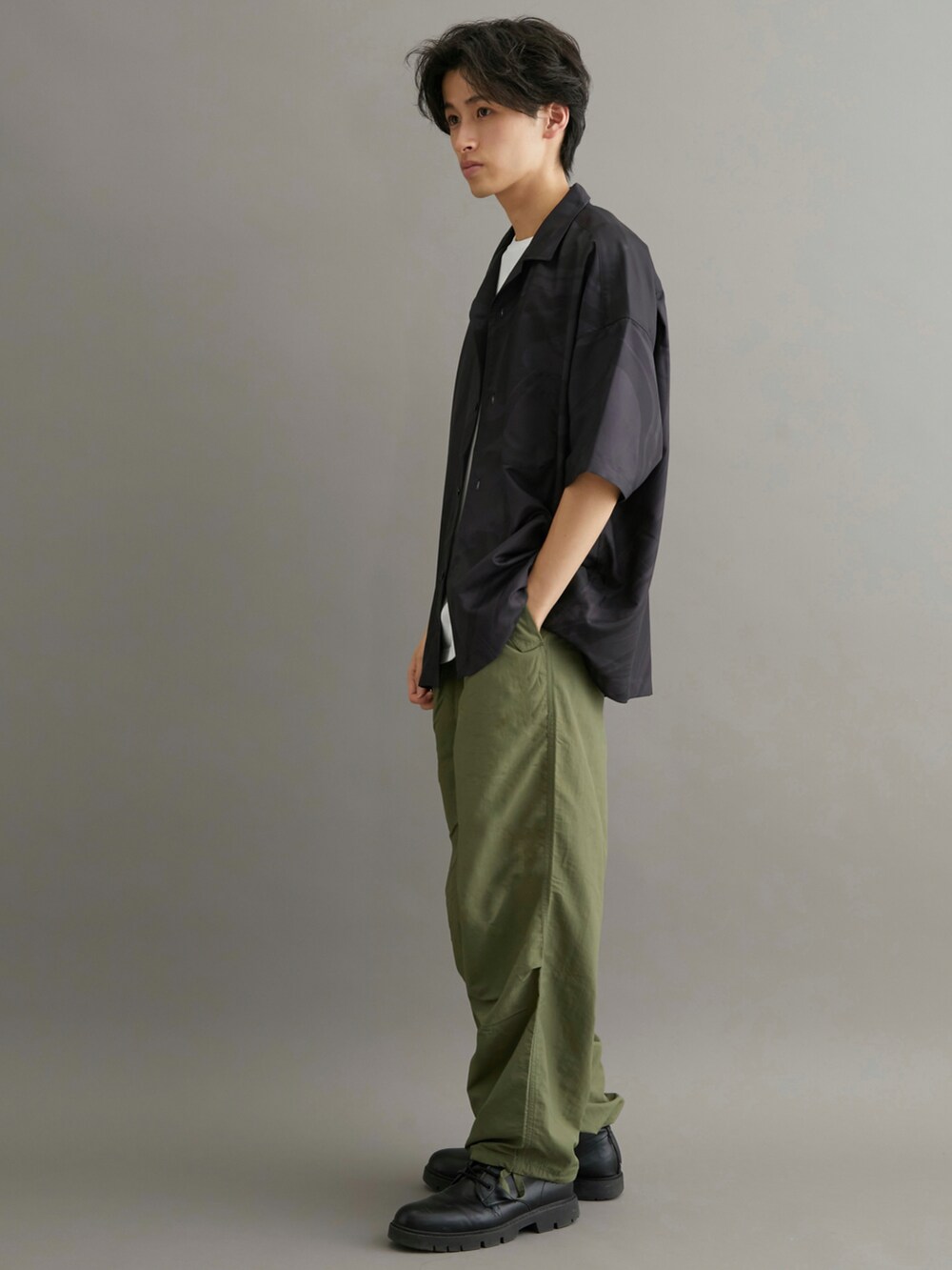 グリーン系のカーゴパンツ、ブラック系のシャツ/ブラウスを着用したメンズの夏コーディネートの2枚目の写真
