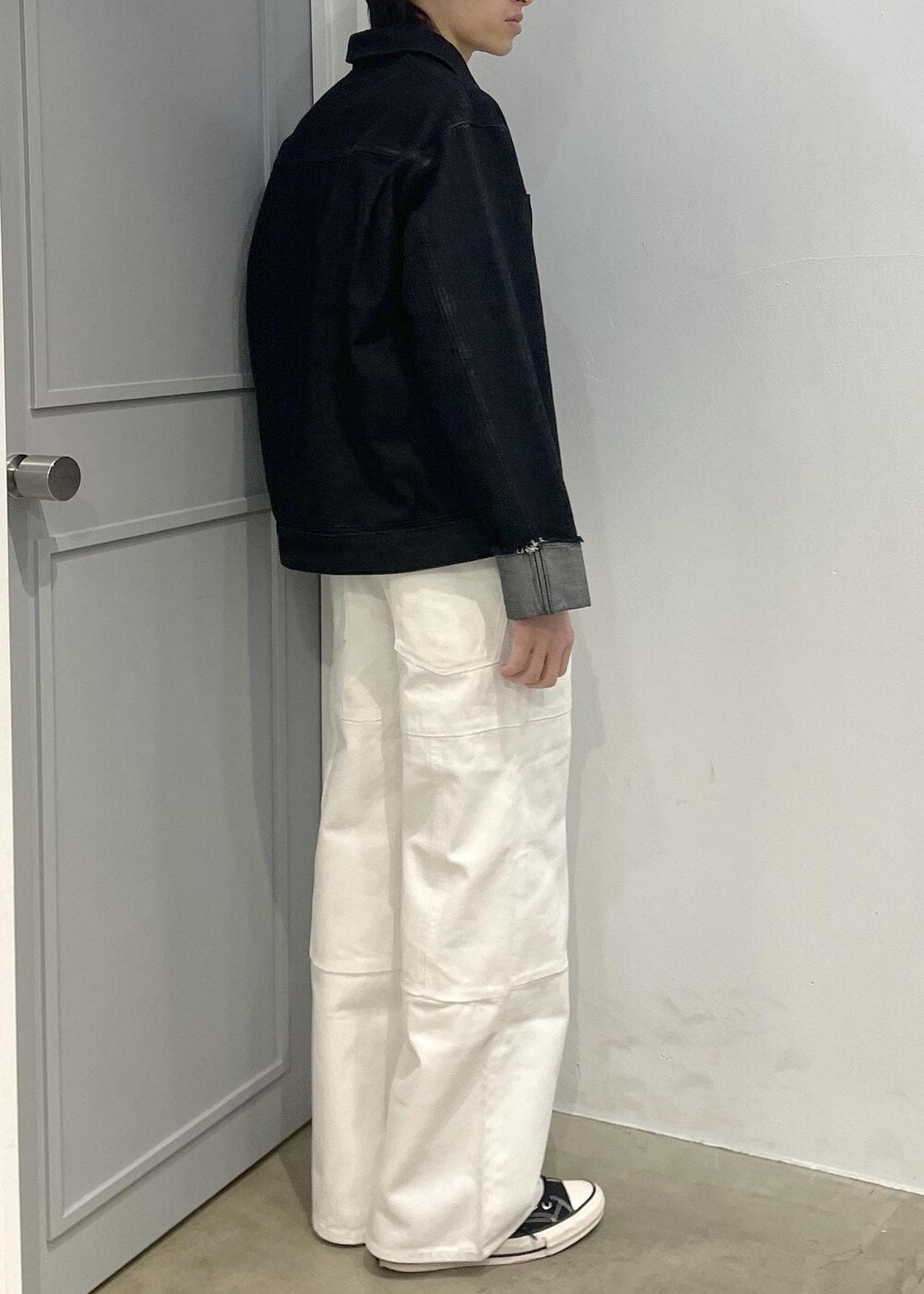 ブラック系のブルゾン、ホワイト系のデニムパンツを着用したメンズの冬コーディネートの3枚目の写真