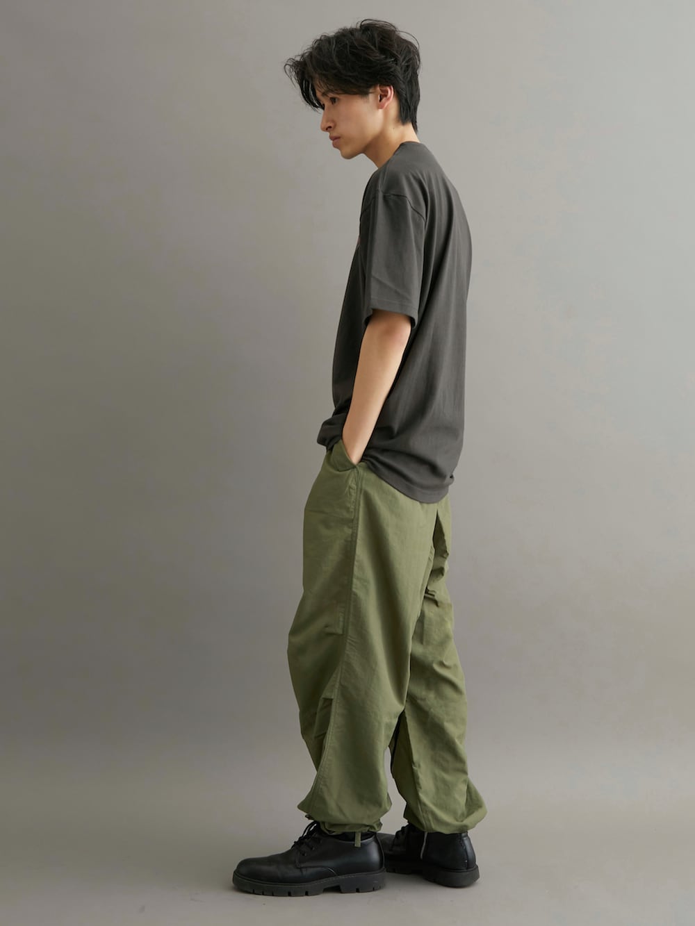 グリーン系のカーゴパンツ、ブラック系のTシャツ/カットソーを着用したメンズの夏コーディネートの2枚目の写真