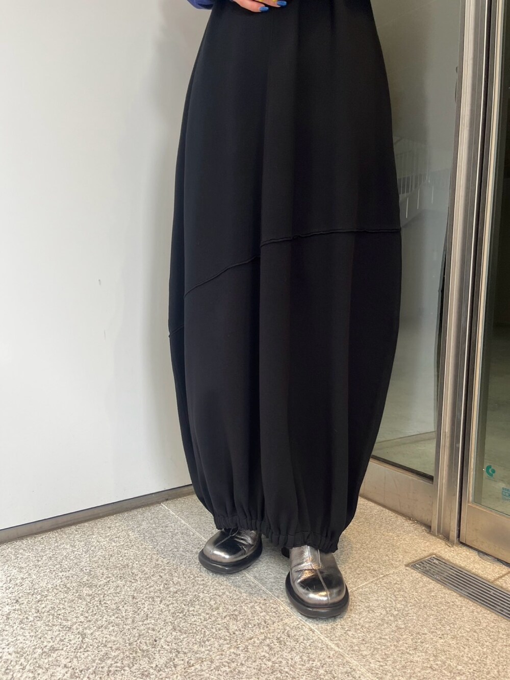 ブラック系のワンピース、シルバー系のブーツを着用したレディースの冬コーディネートの6枚目の写真