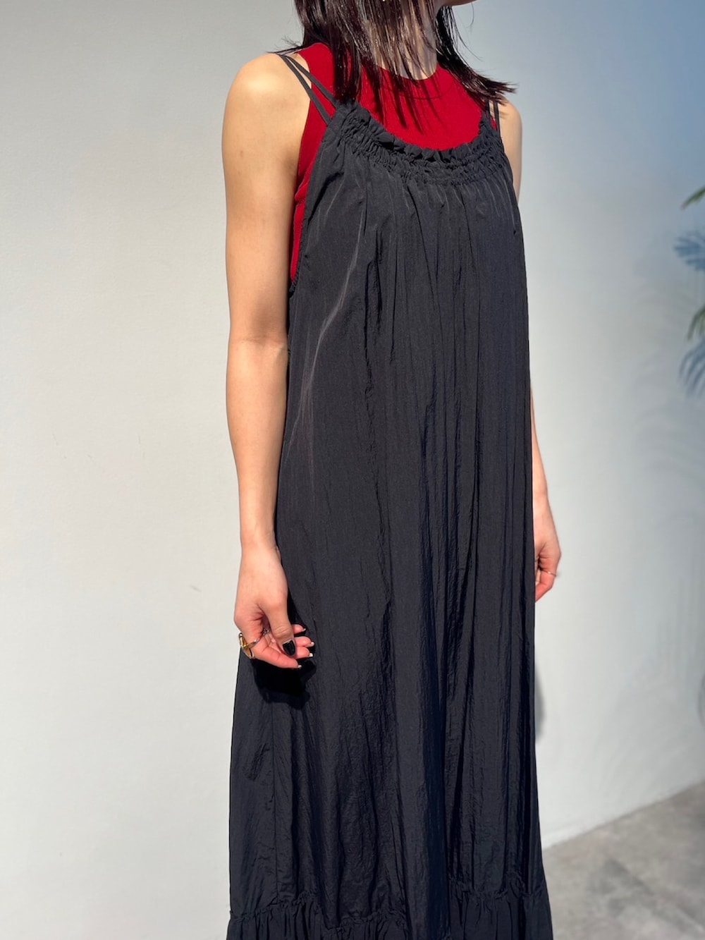 レッド系のタンクトップ、ブラック系のサンダル、ブラック系のスーツケース/キャリーバッグを着用したレディースの春コーディネートの5枚目の写真