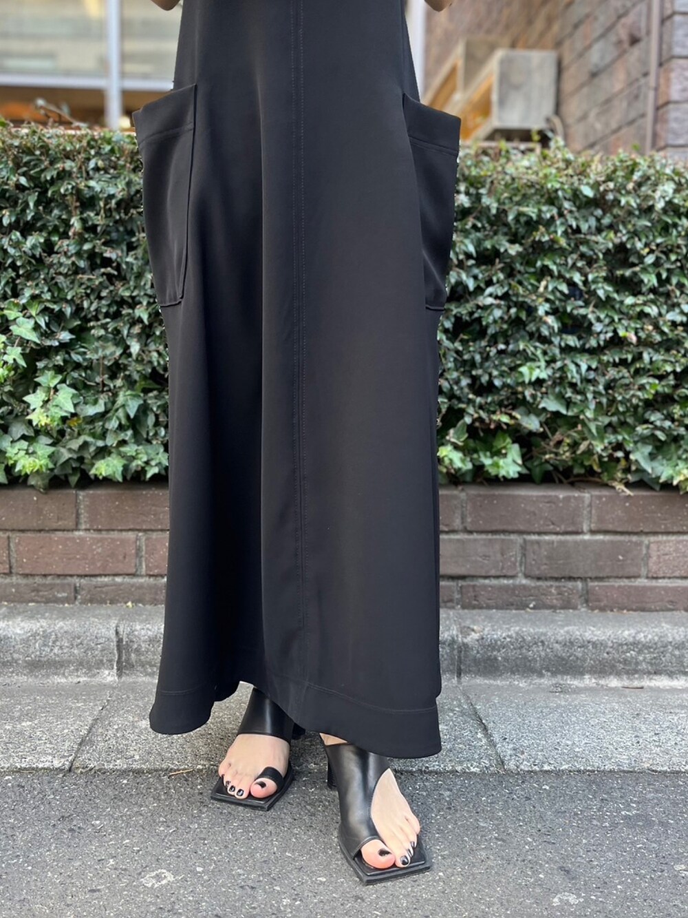 ブラック系のワンピース、ブラック系のサンダル、ブラック系のハットを着用したレディースの春コーディネートの6枚目の写真