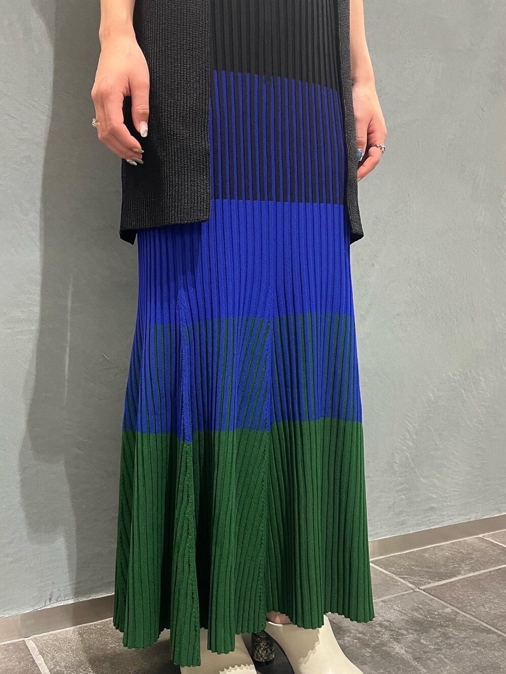 ブラック系のエコバッグ/サブバッグ、ブルー系のスカート、ブラック系のベストを着用したレディースの夏コーディネートの6枚目の写真