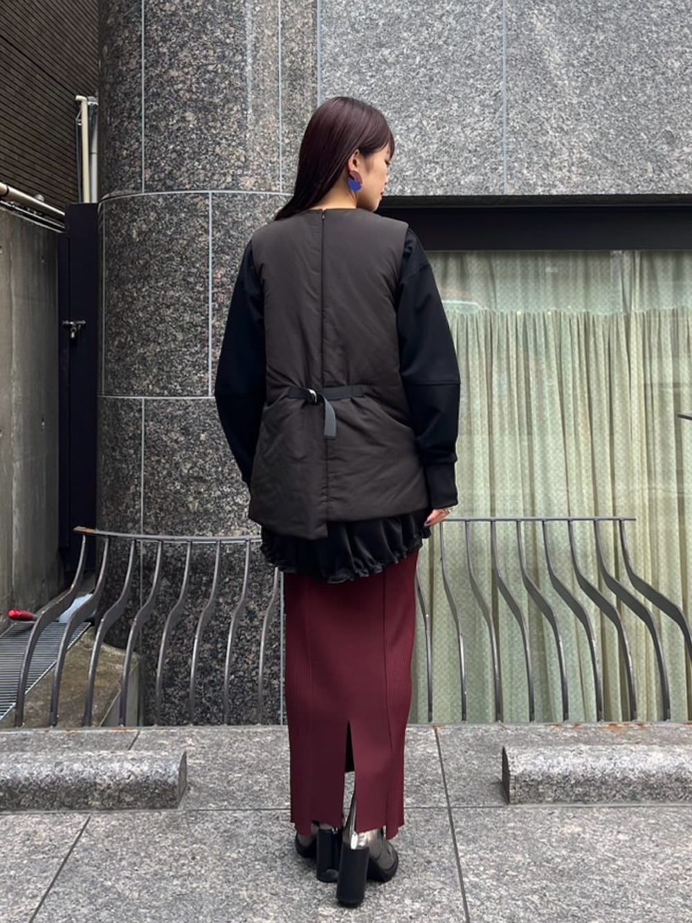 ブラウン系のスカート、ブラック系のTシャツ/カットソー、シルバー系のブーツを着用したレディースの秋コーディネートの2枚目の写真