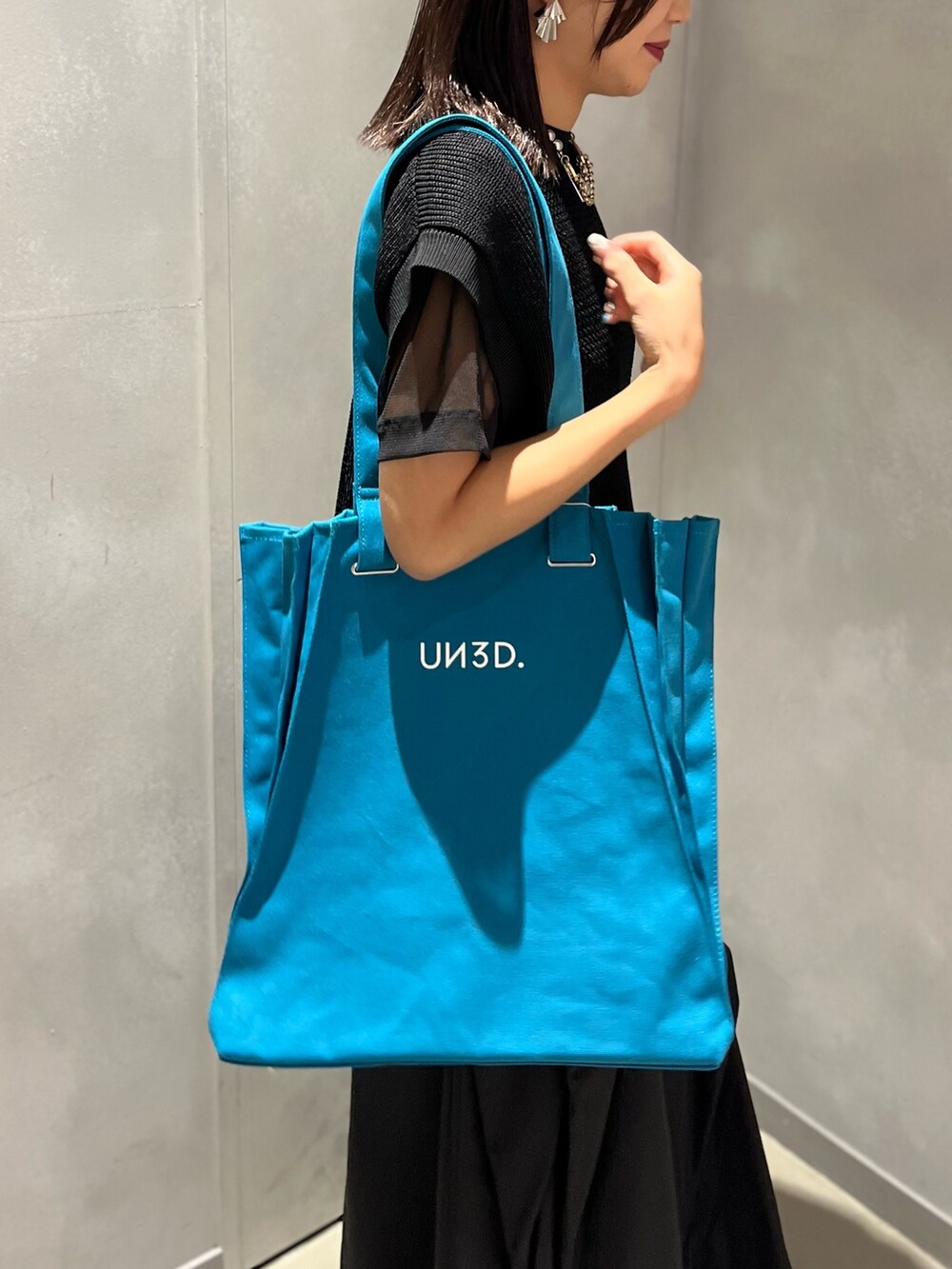 ブラック系のTシャツ/カットソー、ブルー系のトートバッグ、ブラック系のベストを着用したレディースの夏コーディネートの9枚目の写真