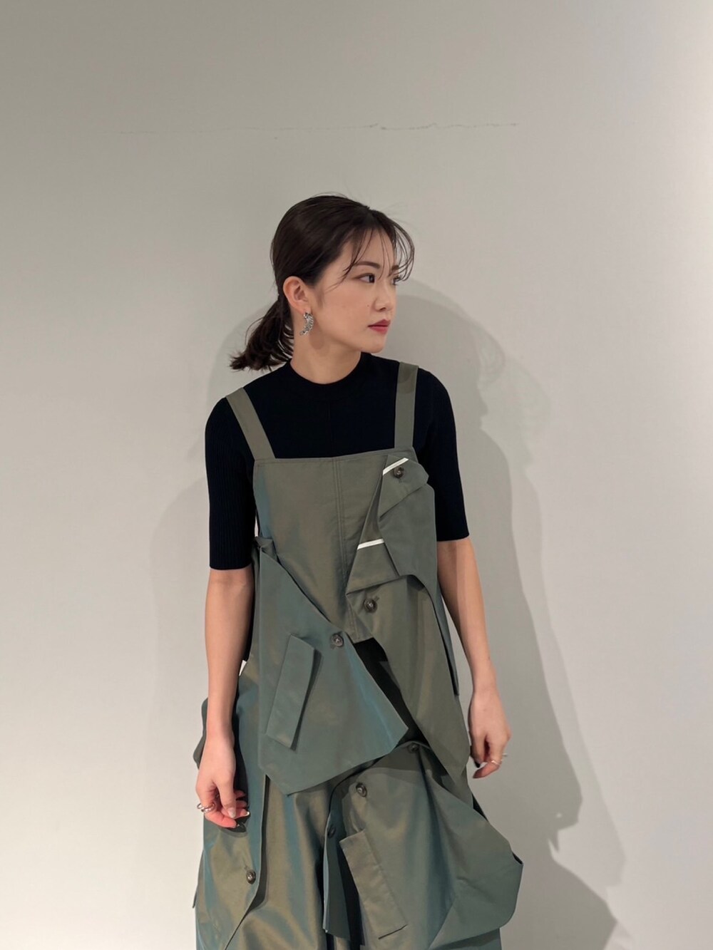 グリーン系のスカート、ベージュ系のキャミソール、ブラック系のサンダルを着用したレディースの冬コーディネートの4枚目の写真