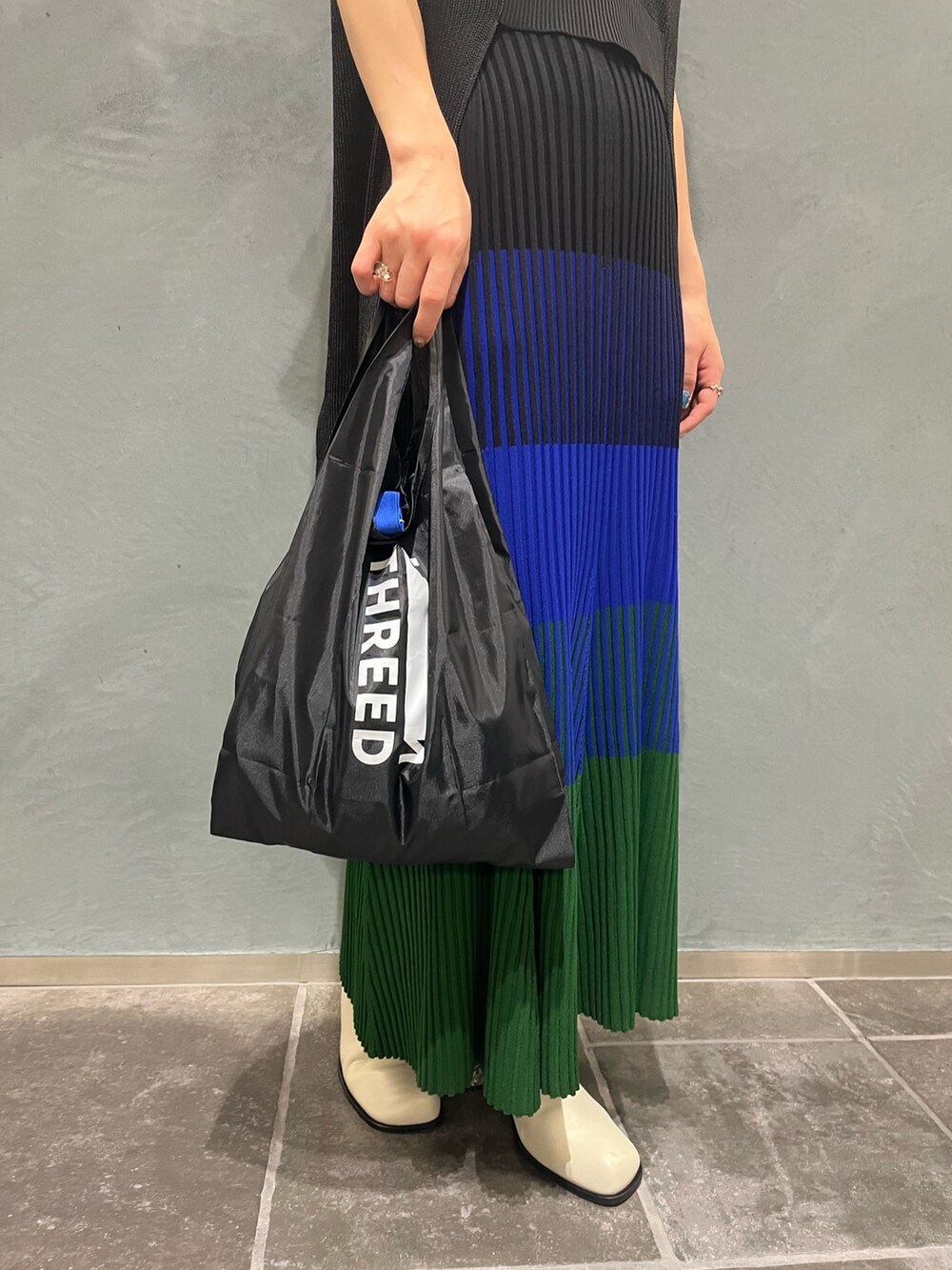 ブラック系のエコバッグ/サブバッグ、ブルー系のスカート、ブラック系のベストを着用したレディースの夏コーディネートの8枚目の写真