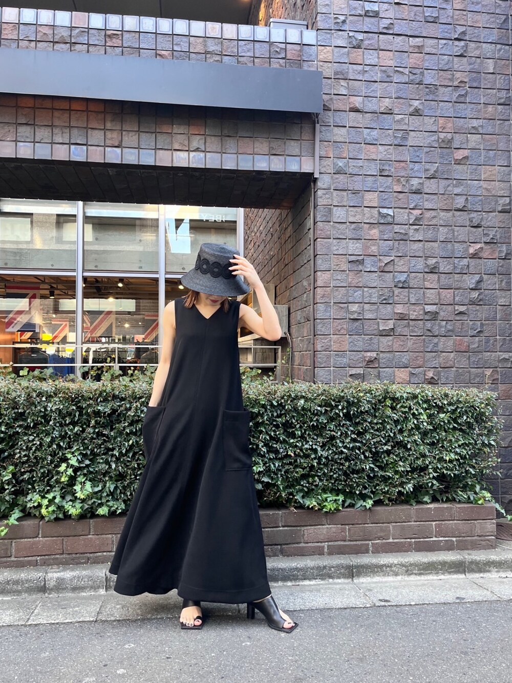 ブラック系のワンピース、ブラック系のサンダル、ブラック系のハットを着用したレディースの春コーディネートの2枚目の写真