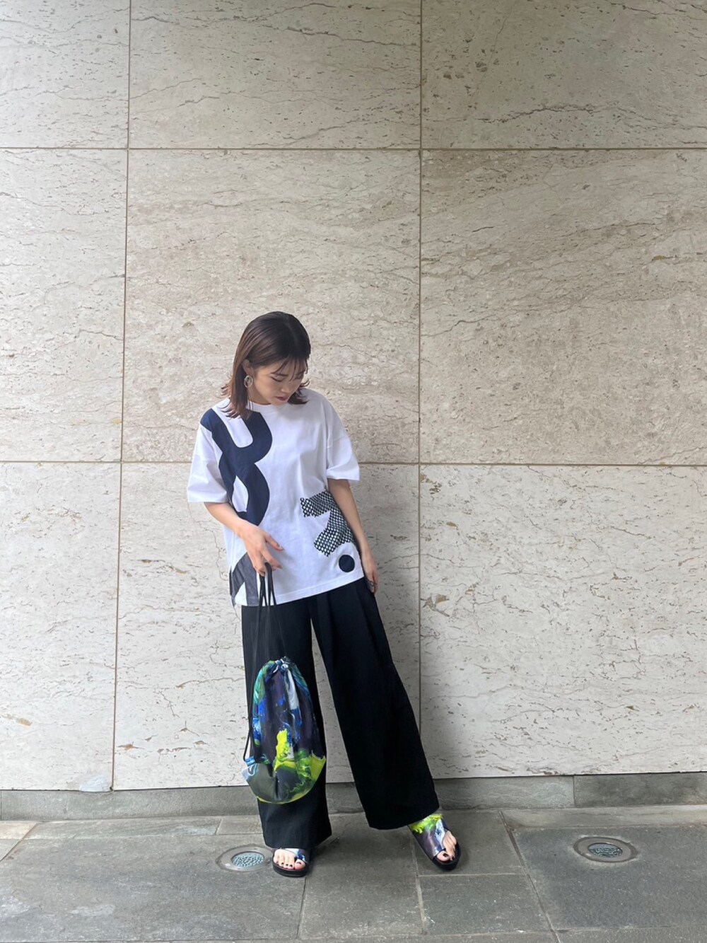 ホワイト系のTシャツ/カットソー、ブラック系のその他パンツ、イエロー系のサンダルを着用したレディースの春コーディネートの2枚目の写真