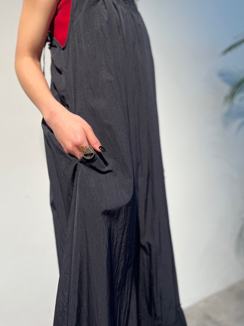 レッド系のタンクトップ、ブラック系のサンダル、ブラック系のスーツケース/キャリーバッグを着用したレディースの春コーディネートの6枚目の写真