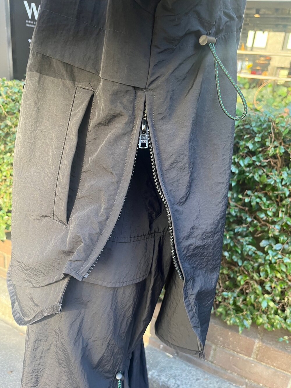 ブラック系のマウンテンパーカー、ブラック系のスカート、シルバー系のブーツを着用したレディースの冬コーディネートの7枚目の写真