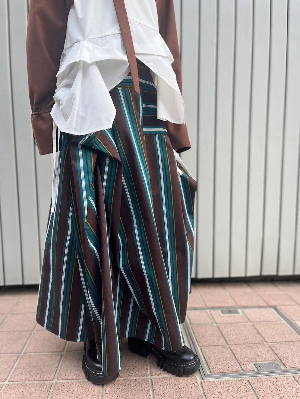 ブラウン系のノーカラージャケット、ホワイト系のTシャツ/カットソー、ブラウン系のスカートを着用したレディースの夏コーディネートの8枚目の写真