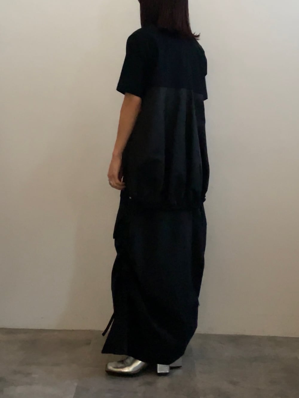 ブラック系のスカート、ブラック系のTシャツ/カットソー、シルバー系のブーツを着用したレディースの冬コーディネートの2枚目の写真