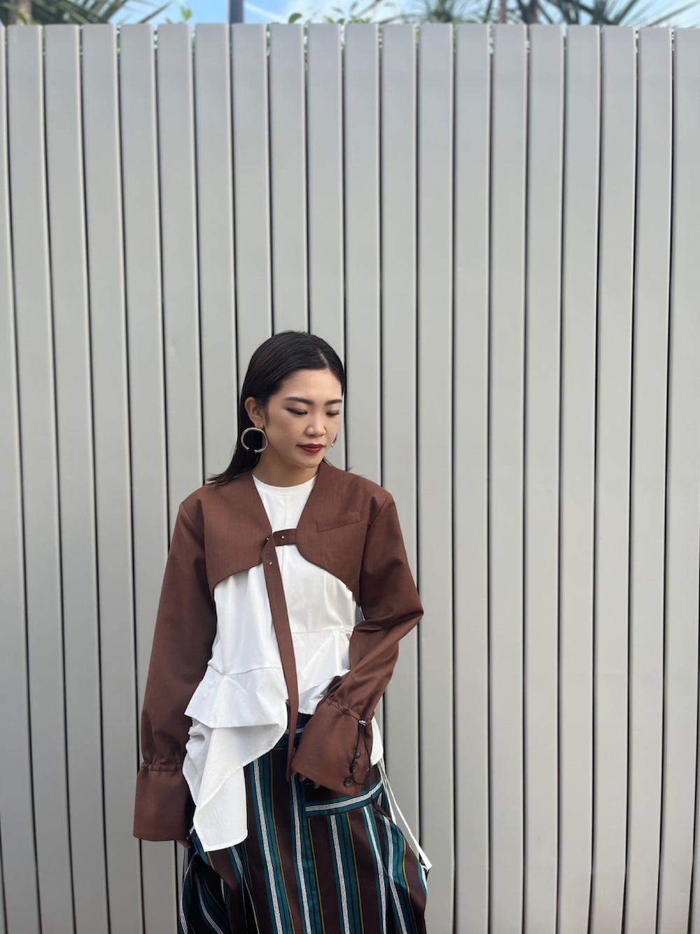 ブラウン系のノーカラージャケット、ホワイト系のTシャツ/カットソー、ブラウン系のスカートを着用したレディースの夏コーディネートの4枚目の写真