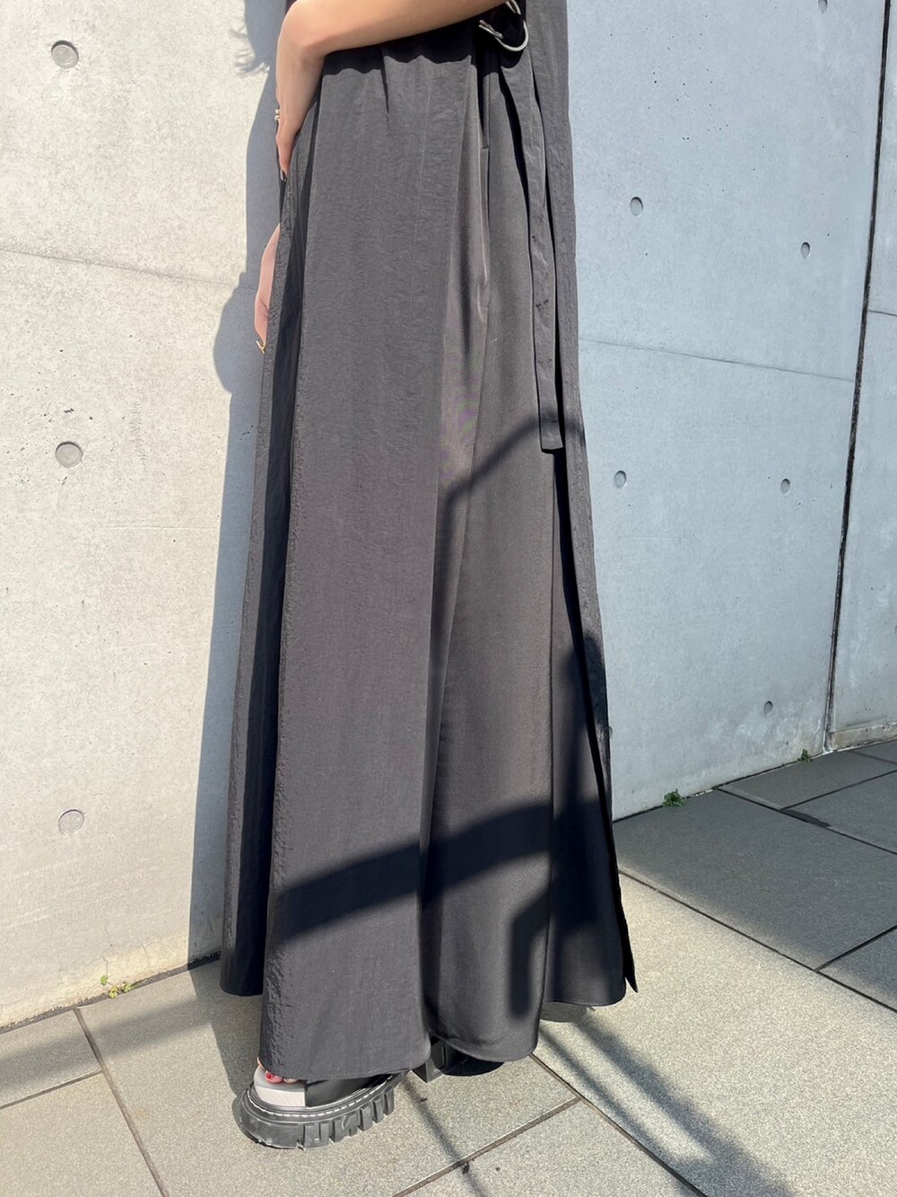 ブラック系のつなぎ/オールインワン、その他のサンダル、ゴールド系のピアス（両耳用）を着用したレディースの春コーディネートの8枚目の写真