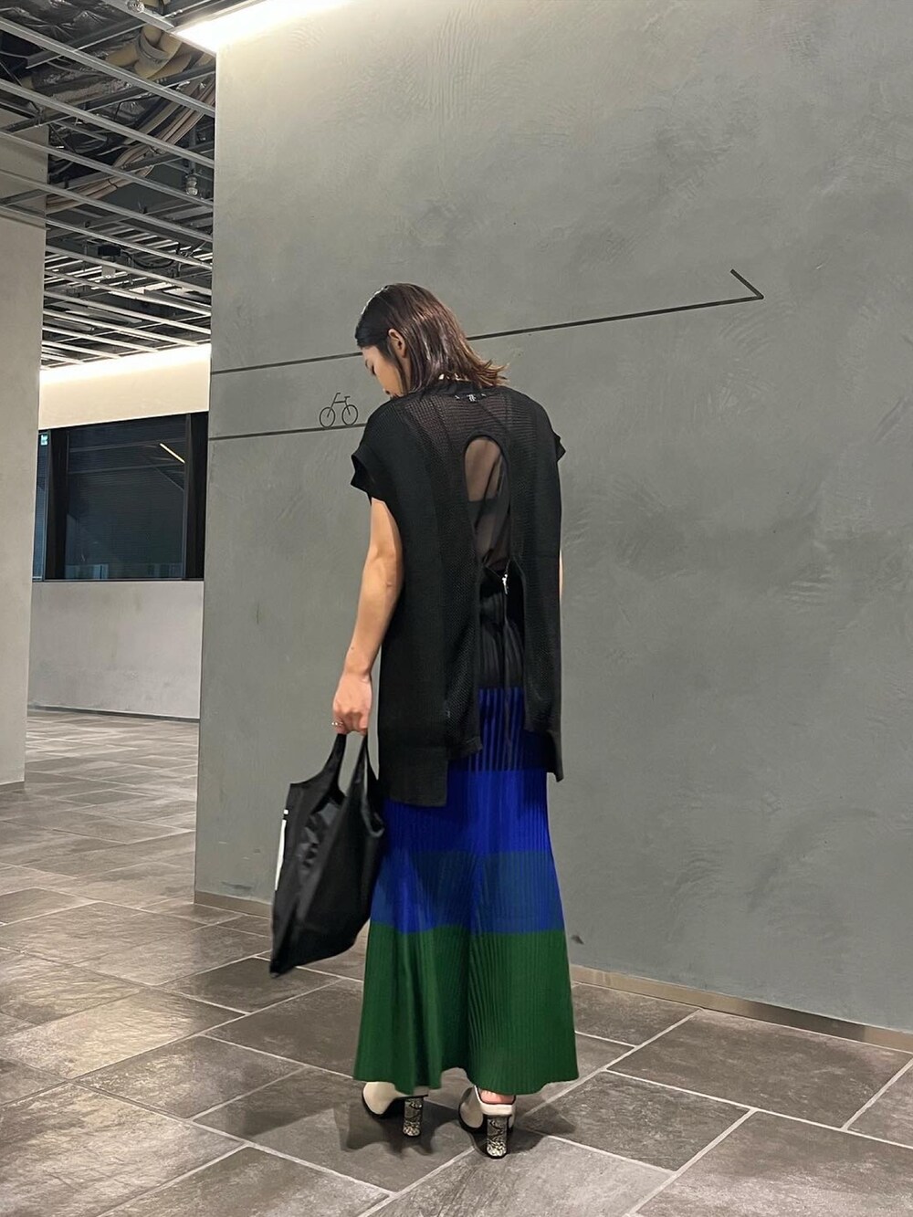 ブラック系のエコバッグ/サブバッグ、ブルー系のスカート、ブラック系のベストを着用したレディースの夏コーディネートの3枚目の写真