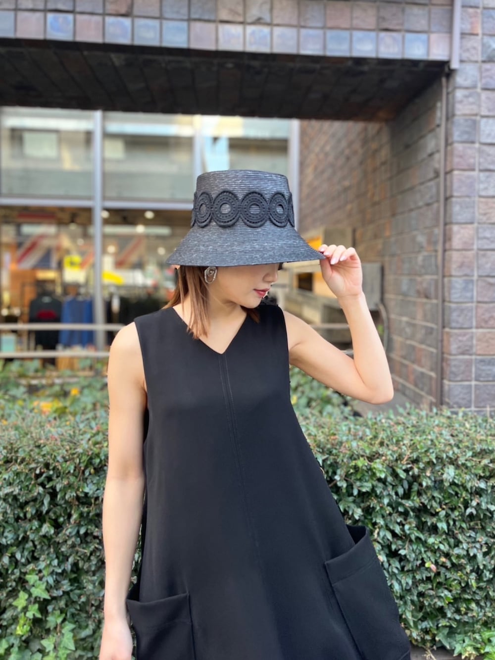 ブラック系のワンピース、ブラック系のサンダル、ブラック系のハットを着用したレディースの春コーディネートの4枚目の写真