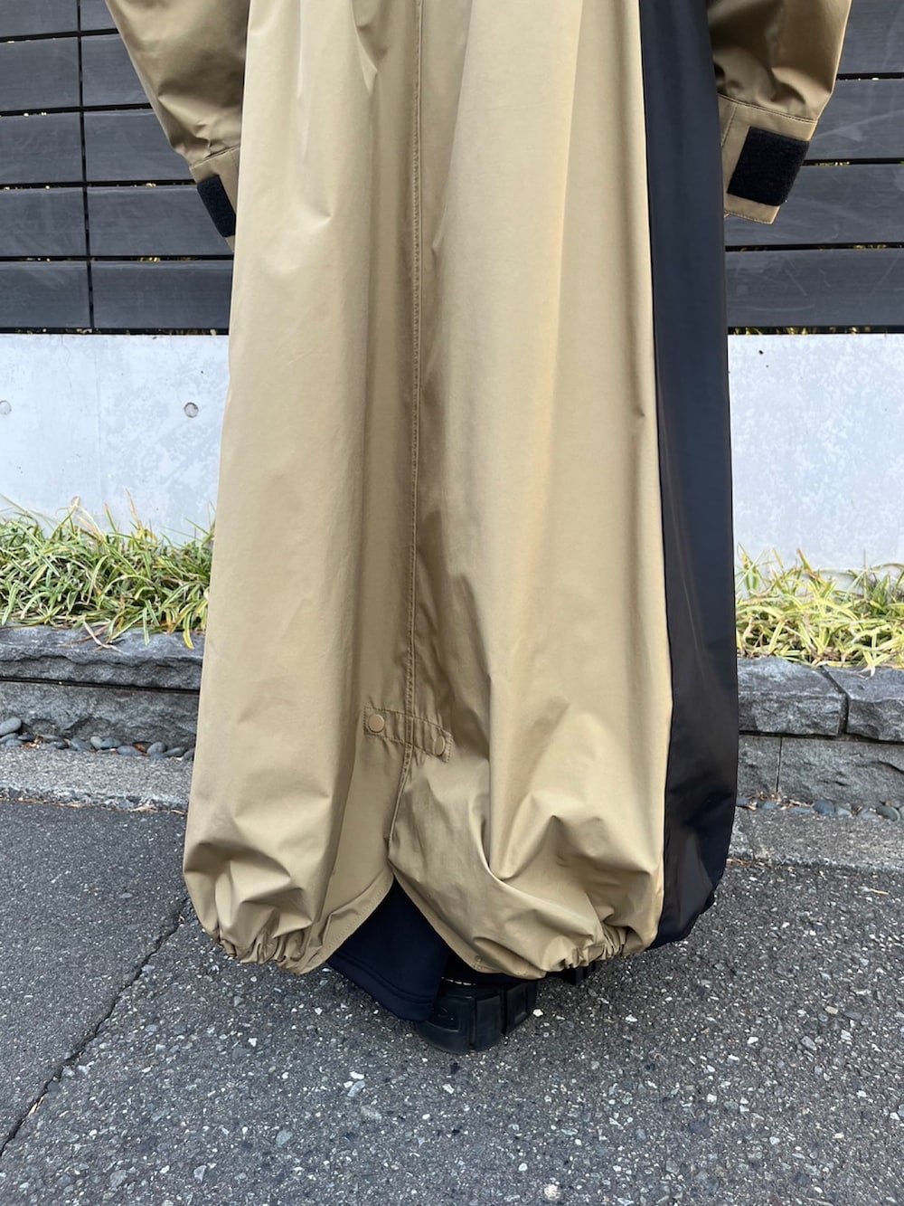 ベージュ系のマウンテンパーカー、ブラック系のワンピース、シルバー系のイヤリングを着用したレディースの冬コーディネートの8枚目の写真